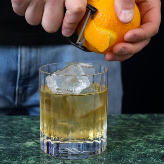 Gheață și coajă de portocală într-un cocktail